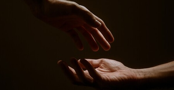 Photo of two hands reaching out