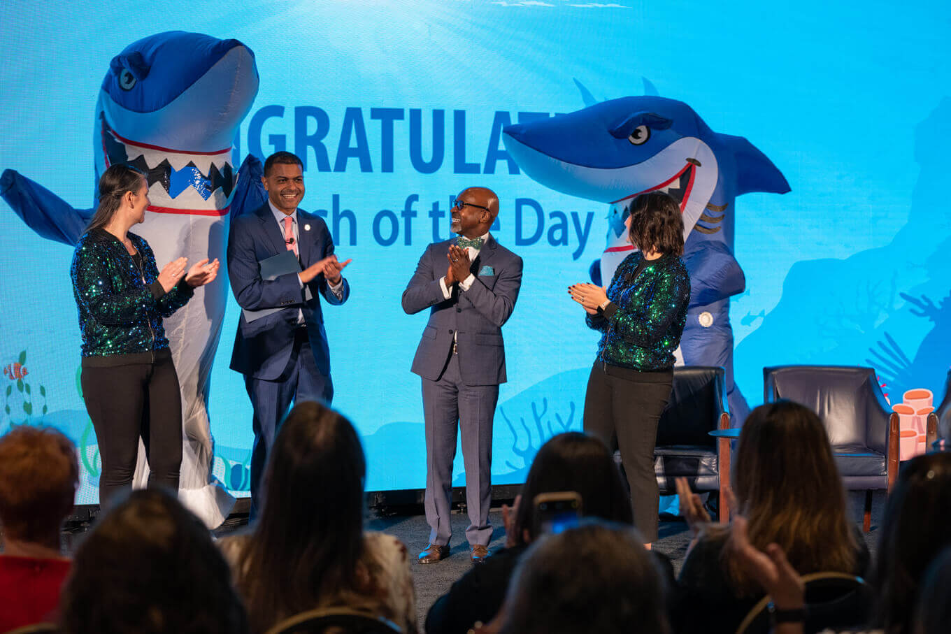 Poster image of contestants and judges on Shark Tank Competition stage