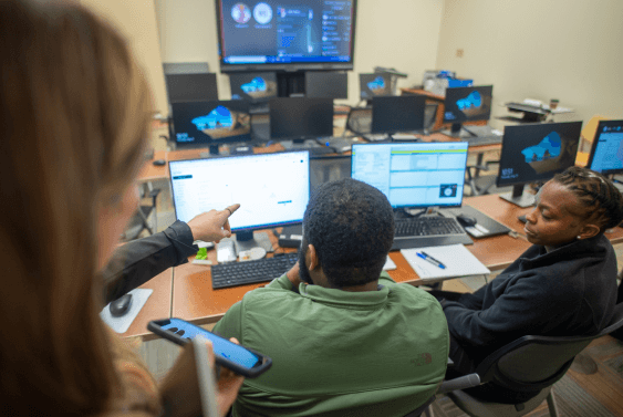 Military veterans sitting at a computer and learning how to use a piece of software