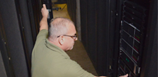 A man looking at computer servers
